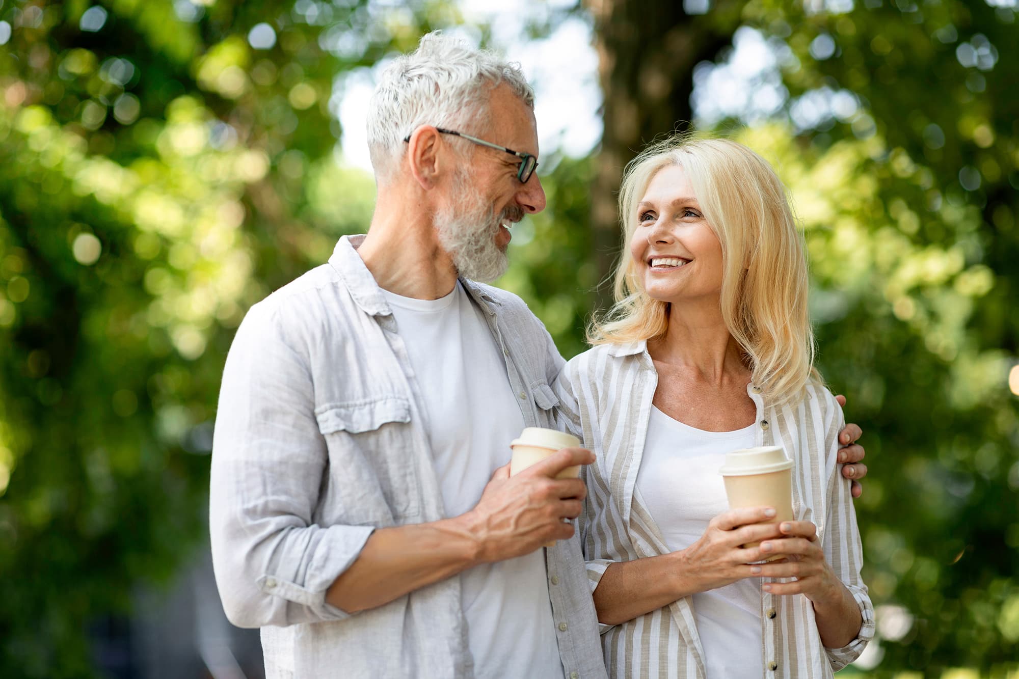 Man and woman drinking coffee outside their Livana Fair Lawn rental apartment